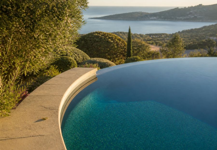 Poolrand einer mediterranen Villa bei ruhigem Wasser